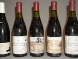 six bouteilles de vin sont alignées sur une table