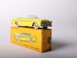 yellow toy car sitting on top of a yellow box on a white surface