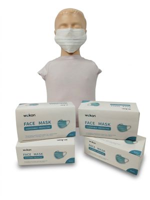 trois boîtes de masques faciaux et une tête de mannequin sur fond blanc