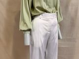 an image of a mannequin wearing a green shirt and white pants