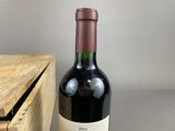 a bottle of wine sitting on a table next to a wooden box