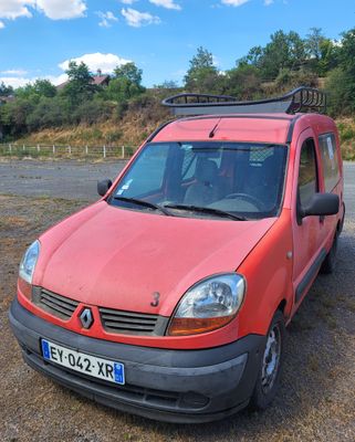 une camionnette rouge garée sur un parking