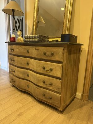 a dresser with a mirror on top of it in a room