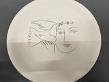 a white frisbee with a drawing of a woman and a bird on it