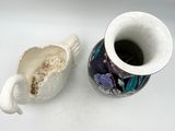 a cup with a handle sitting next to a cup with a handle