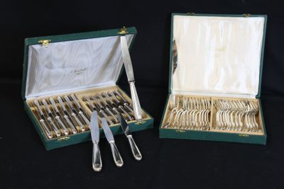 deux sets d'argenterie dans un coffret sur une table