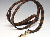 un gros plan d'une ceinture marron et noire avec une boucle dorée