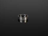 gros plan d'une bague en argent sur une surface noire