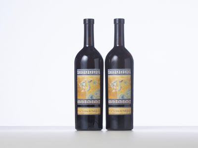two bottles of wine sitting on top of a white table