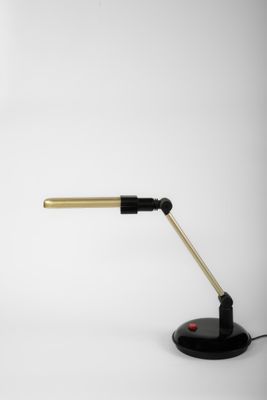 une image représentant une lampe de bureau noire et dorée sur fond blanc
