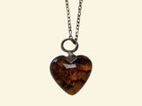 a close up of a heart shaped pendant on a chain