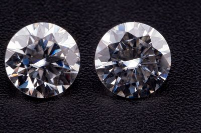 deux diamants ronds taille brillant sur un fond noir