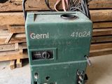 an image of a green machine sitting on top of a pile of wood