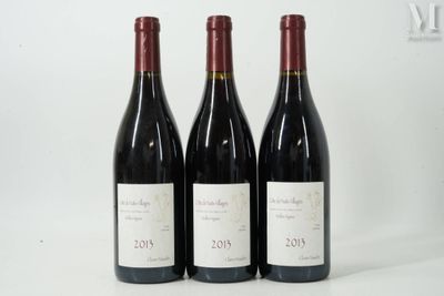 trois bouteilles de vin rouge sont alignées sur une surface blanche