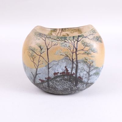 un petit vase avec une peinture sur une surface blanche