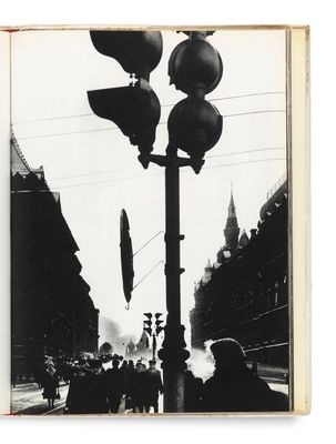 une photo en noir et blanc représentant un lampadaire et une foule de gens