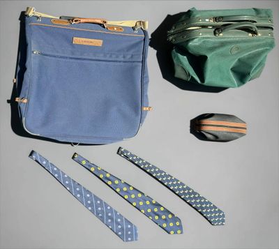 several ties, a bag, and a tie are laid out on a table