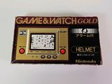 an old game and watch gold box sitting on top of a table