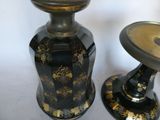 two black and gold vases sitting next to each other