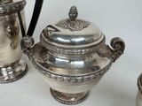 a silver tea pot and a silver teapot on a table
