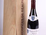 a bottle of red wine in front of a wooden box