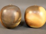 deux pommes dorées posées l'une à côté de l'autre sur une table