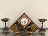 a clock sitting on top of a glass shelf next to two candles