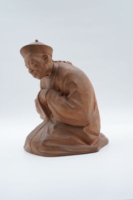 une image représentant la statue d'un homme agenouillé sur une surface blanche
