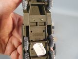 a person holding a toy army vehicle in their hand