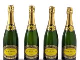 trois bouteilles de champagne posées les unes à côté des autres sur une surface blanche