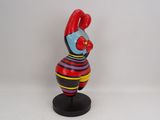a small figurine of a clown on a black stand