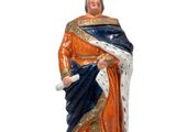 statue d'un homme vêtu d'orange et de bleu, coiffé d'une couronne