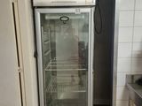 a refrigerator that is open in a kitchen with tile flooring