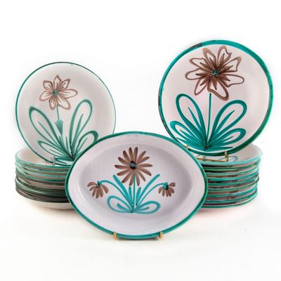 une pile d'assiettes ornées de fleurs, posées sur une surface blanche
