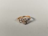 a close up of a gold and diamond ring on a white surface