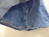 two pairs of denim shorts hanging on a clothes rack