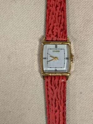 une image représentant une montre rouge avec un cadran blanc et un bracelet rouge
