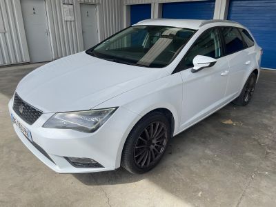 une voiture blanche garée dans un garage, à côté d'une porte de garage bleue