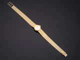 a gold watch with a white dial on a black background