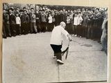 black and white photograph of a man playing tennis in front of a crowd of people