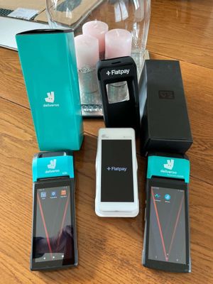 Plusieurs téléphones portables sont posés sur une table, à côté d'un verre d'eau.
