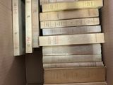 many books in a cardboard box on the floor