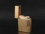 un briquet doré posé sur une surface noire
