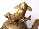 a bronze statue of a dog on top of a bell