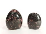 deux pierres noires et roses posées sur une surface blanche