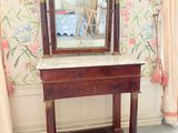 un miroir posé sur une table dans une pièce au papier peint à motifs floraux