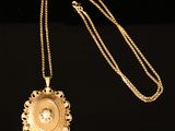un gros plan sur un collier en or orné d'un diamant au centre
