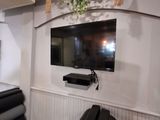 une télévision fixée au mur au-dessus d'un canapé