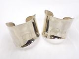 une paire de bracelets manchette en argent sur fond blanc