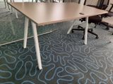 tables and chairs in an office setting with a glass wall